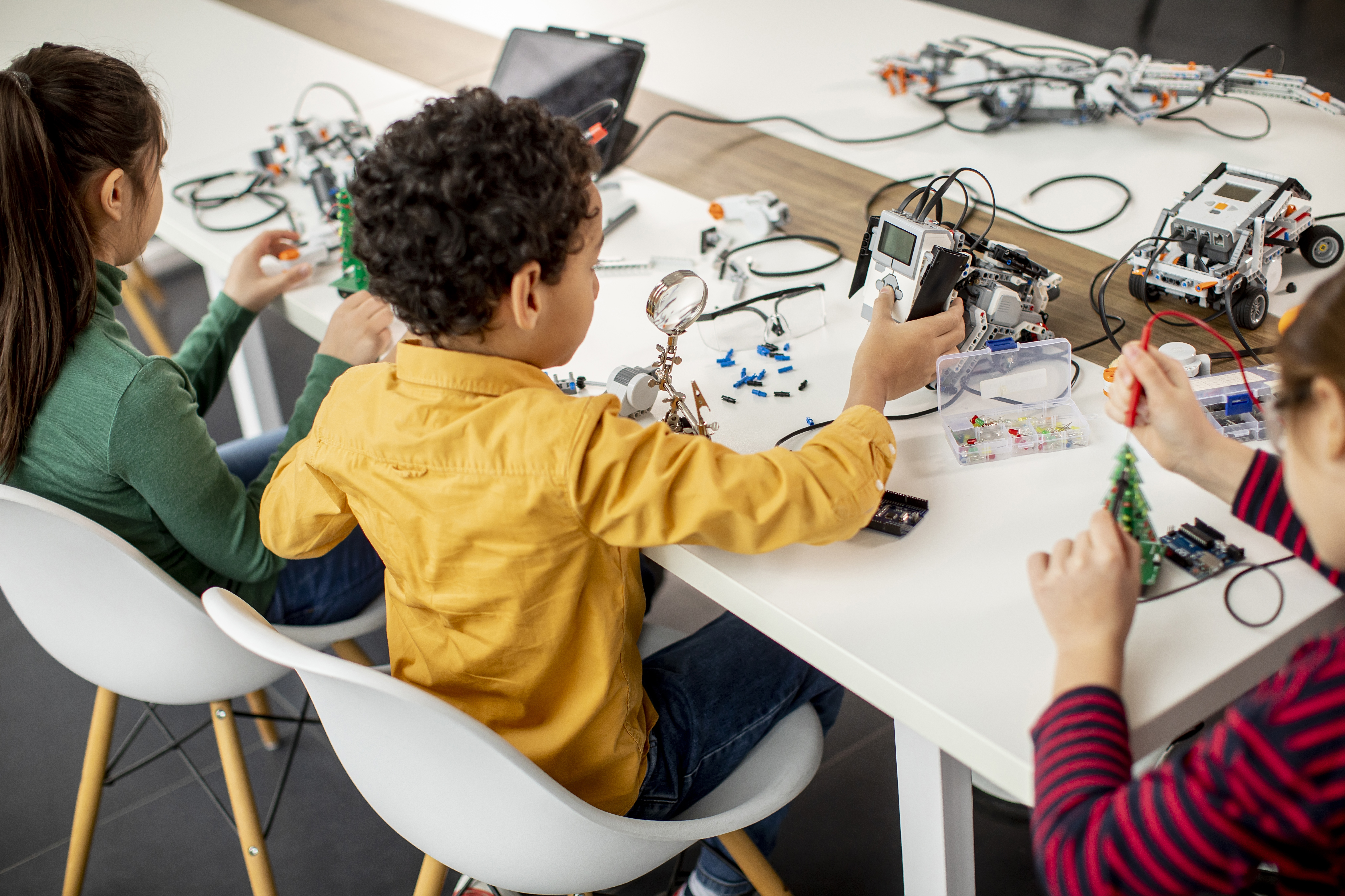 Niños aprendiendo robótica y programación en un aula moderna